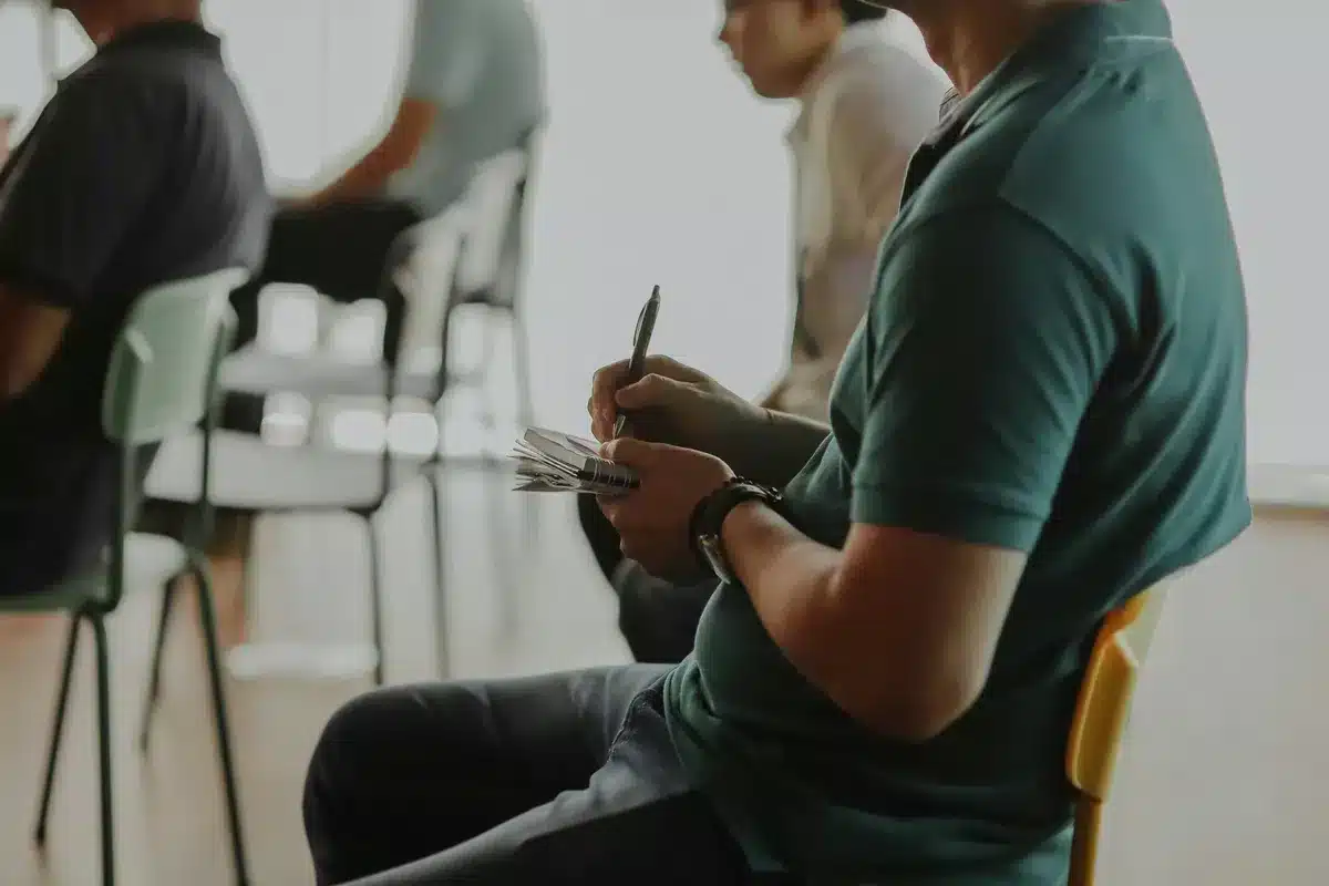 Groupe de participants prenant des notes lors d’un atelier de reclassement organisé par Brio PAE